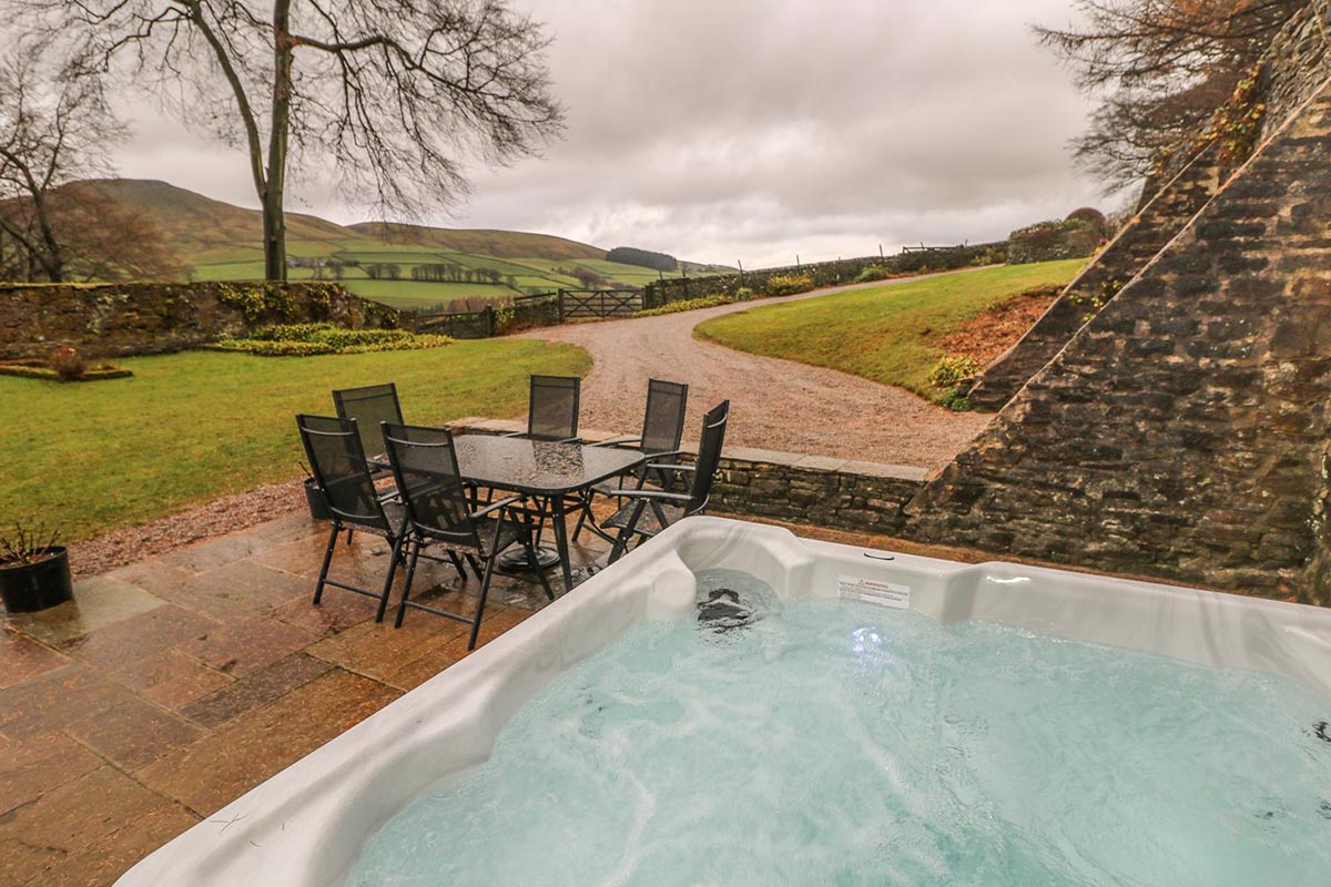 Hot tub and patio table and chairs with views of the countryside